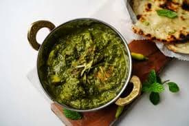 A rich, green Palak Chicken curry in a serving bowl.